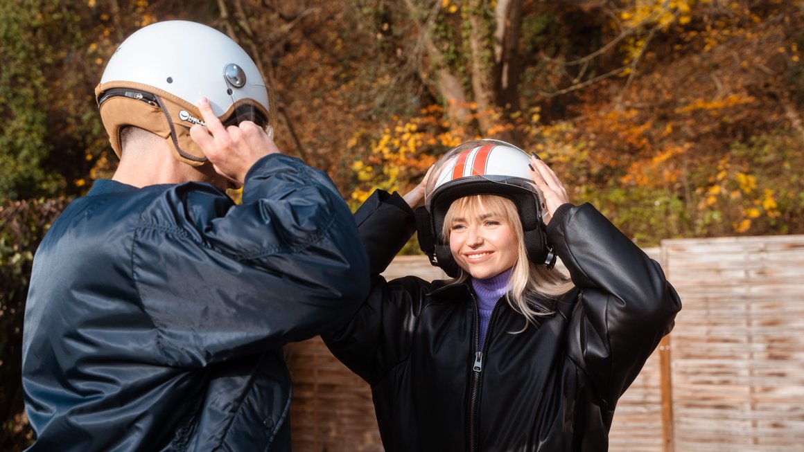 Mädchen und Junge setzen einen Helm auf