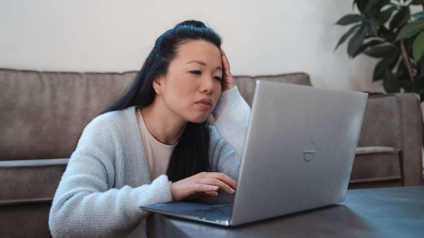 Pourquoi les dettes peuvent être dangereuses Une femme assise devant son ordinateur portable