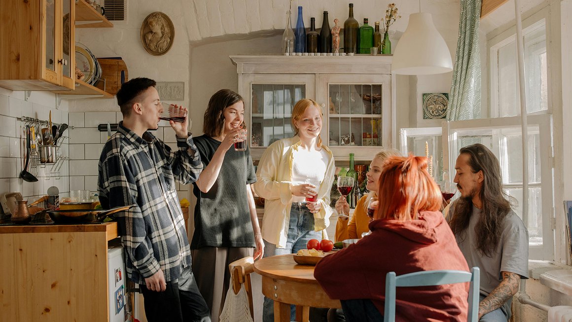 Un groupe de jeunes assis ensemble dans la cuisine.