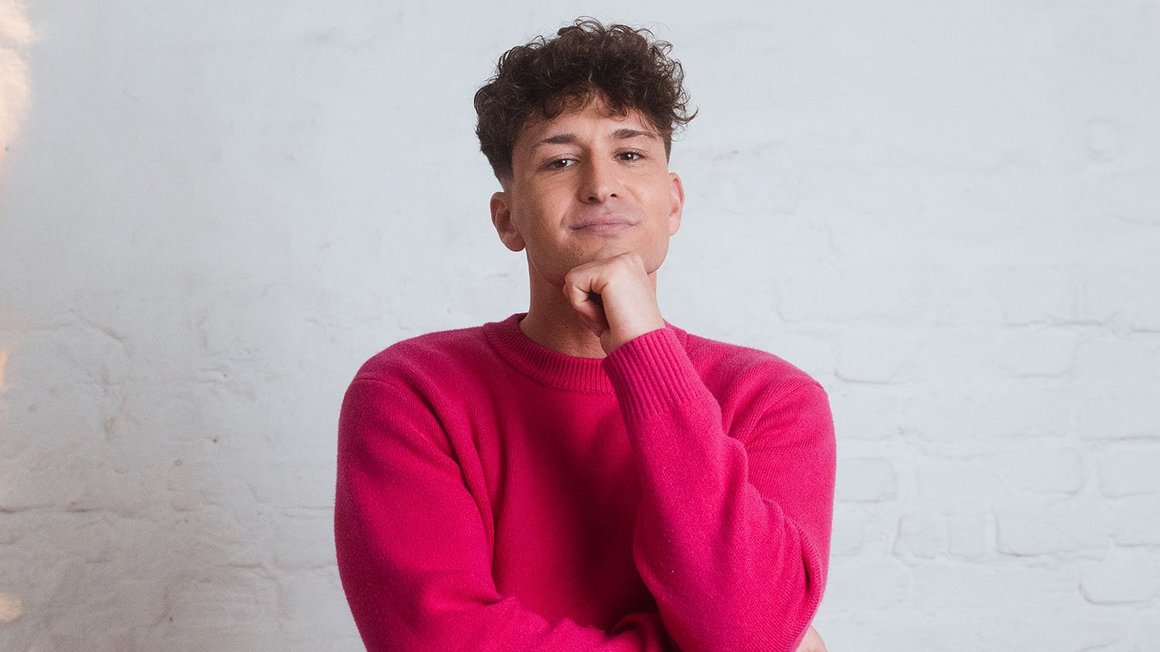 Sicherheit zuerst: Schuldenabbau und Notgroschen Mann mit pinkem Pullover guckt nachdenklich in die Kamera