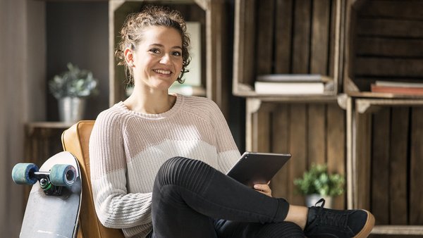 Jeune femme tient un livre des comptes sur tablette